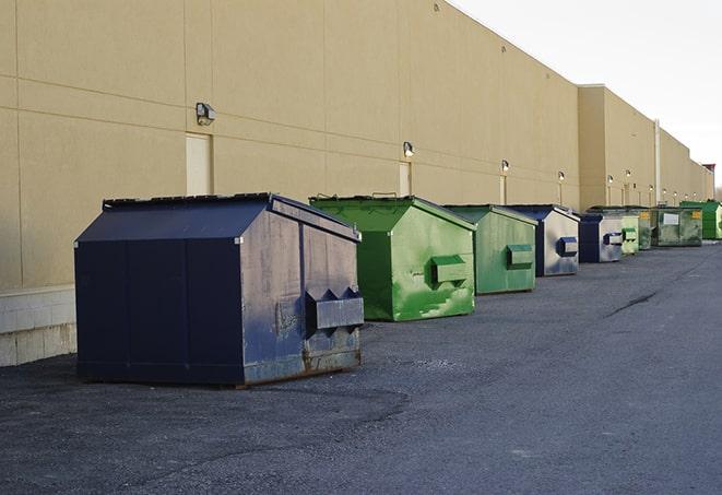 construction workers loading debris into dumpsters on a worksite in Alto, NM